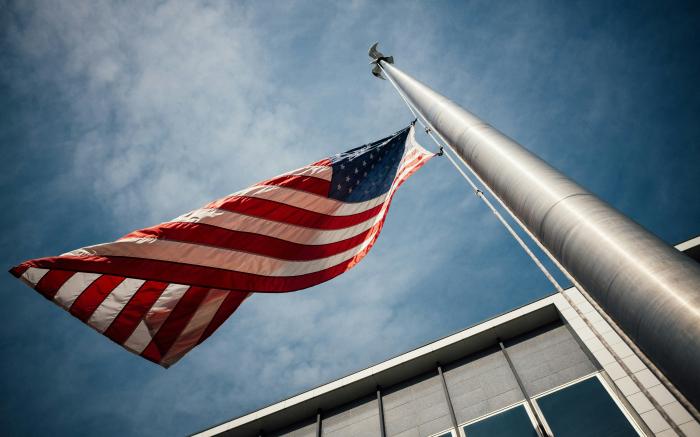 low-angle photo of U.S. flag placed on gray pole by Jonathan Simcoe courtesy of Unsplash.
